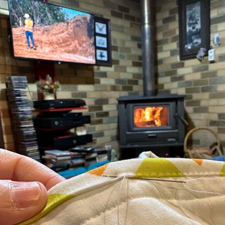 The definition of cozy: handsewing a quilt binding in front of a fire while watching Grand Designs on a winter night… 🧵🪡❤️🔥