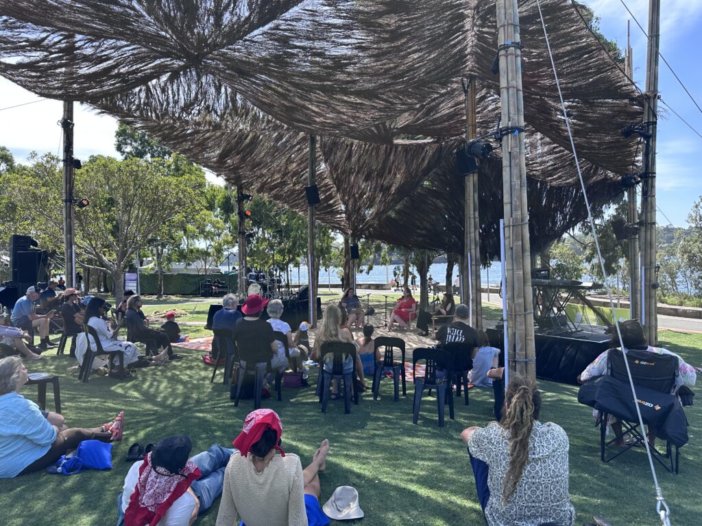 Vigil: Gunyah talk at Sydney Festival - a crowd of people watching three Aboriginal women speak at Barangaroo Reserve