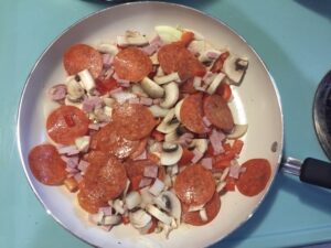 Step 1: “Pepperoni onions ham red pepper garlic sautéed in olive oil” (Incidentally, their stove is vintage and ADORABLE. It’s from the 60s and it’s blue with chunky buttons. I love it.) https://t.co/fzcoenEI8X