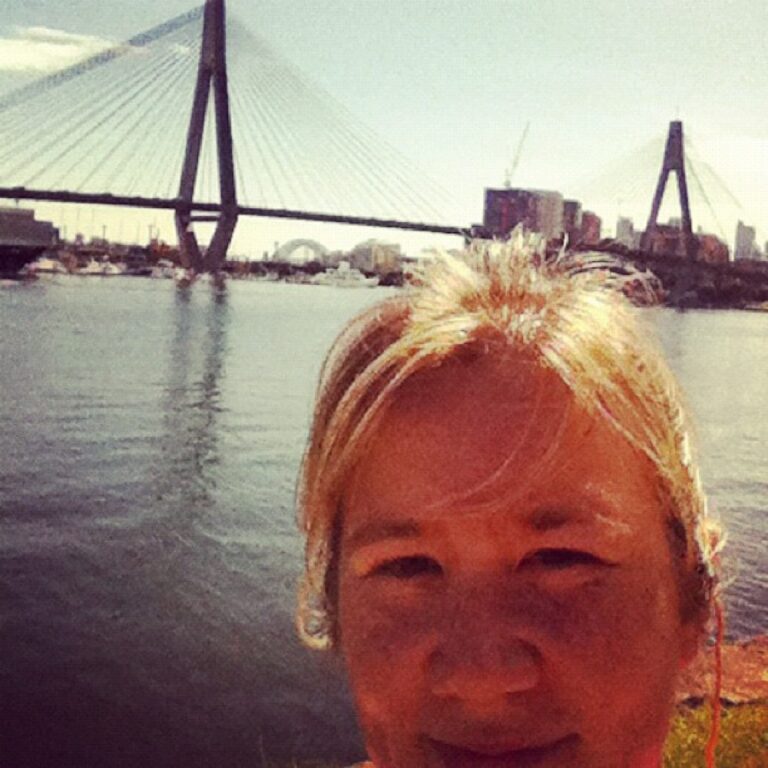 Self-portrait in the middle of a run around Blackwattle Bay, Sydney's bridges behind me.