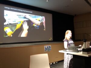 It's a rule that every knitting and programming talk has to mention punchcards. 😂 @chixors explaining knitting machines to a crowd of folks who've mainly never seen them! #artandtech #lca2018 https://t.co/Qsc8K3atyK