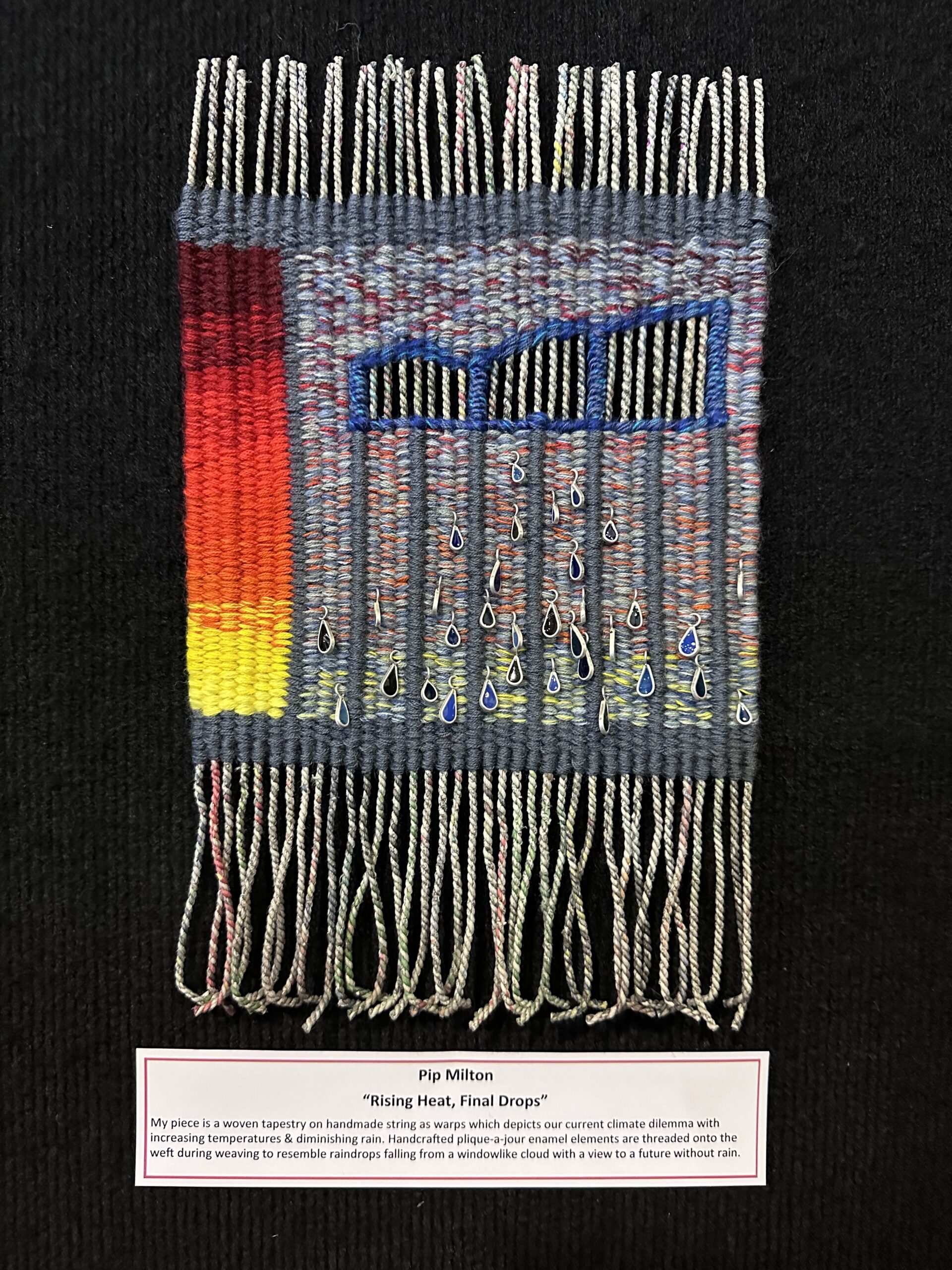 A small woven artwork referencing climate change, showing rising temperatures and raindrop beads