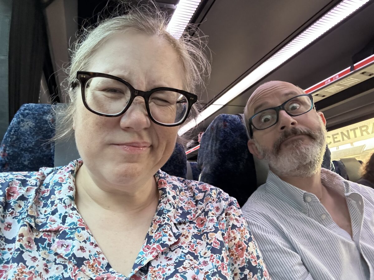 Selfie of two tired-looking white people on a train