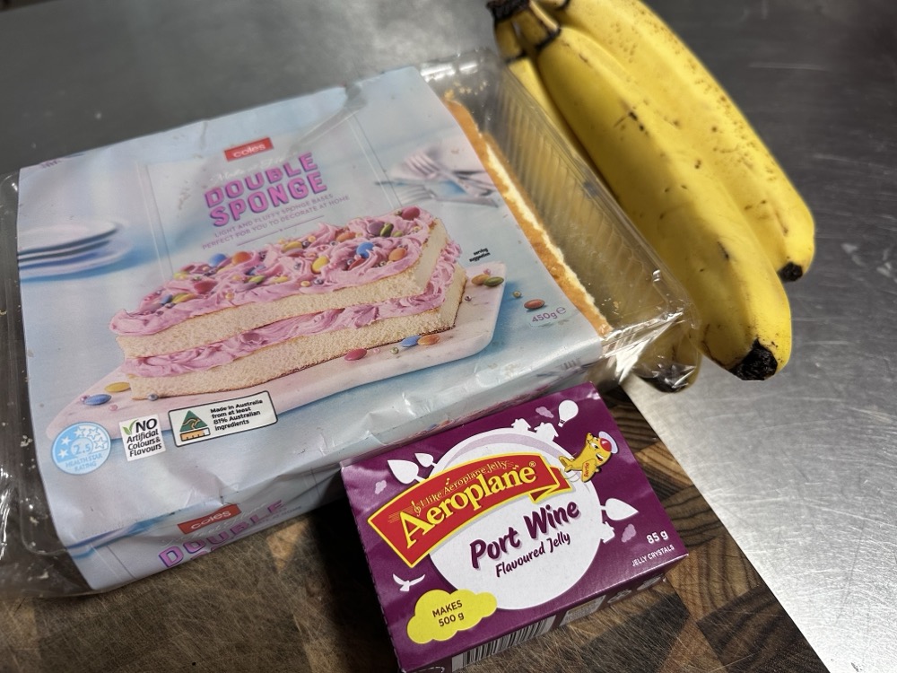 A packaged sponge cake, a box of flavoured gelatin, and bananas