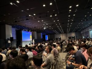 I am very excited to be at Rory Richardson’s keynote to kick off #AWSDevDay Tokyo! She shared that Amazon CodeWhisperer is now one of the fastest growing services in AWS history. I especially like Rory’s analogy that generative AI is the “microwave popcorn” of machine learning, the “killer app” that catches people’s attention and helps the technology reach critical mass. If you are at #AWSDevDay: I will be on this stage tomorrow morning talking about “finding your place as a developer,” and feeling confident while avoiding burnout and stress. I also have a large bag of stickers, including #AWSdress stickers! ❤️