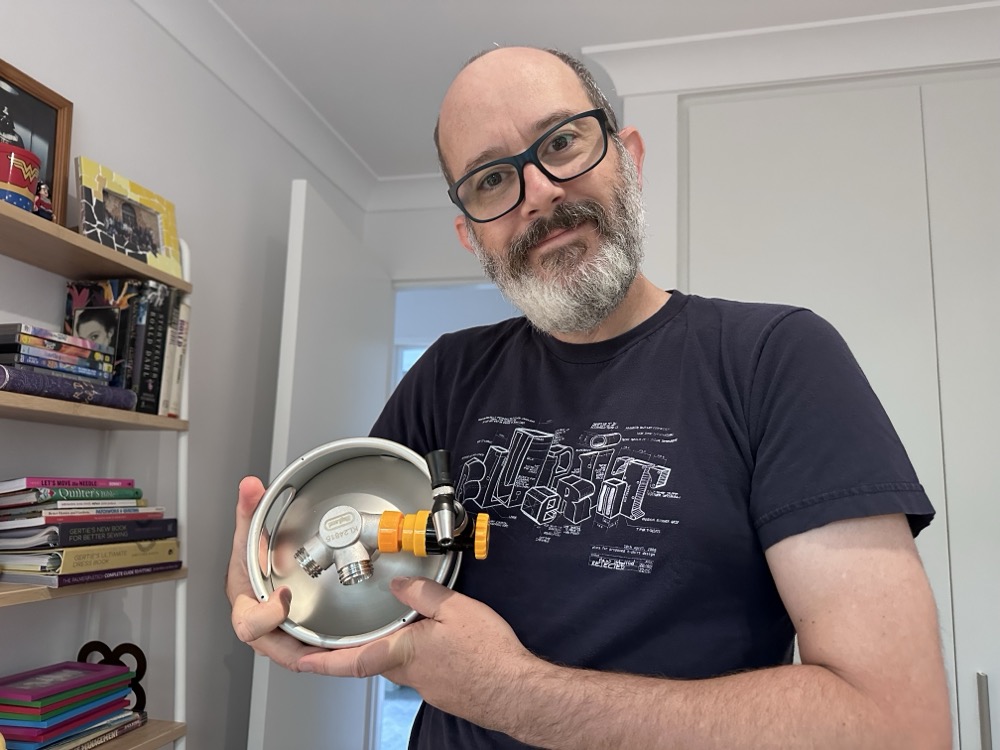 A beardy man hugging a mini beer keg