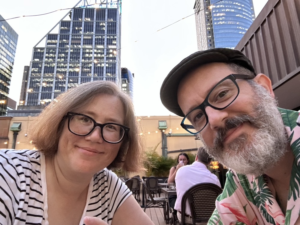 Two people talking a sunset selfie on a rooftop